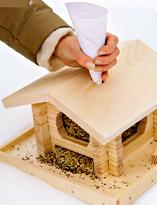 Наполнение кормушки семенами