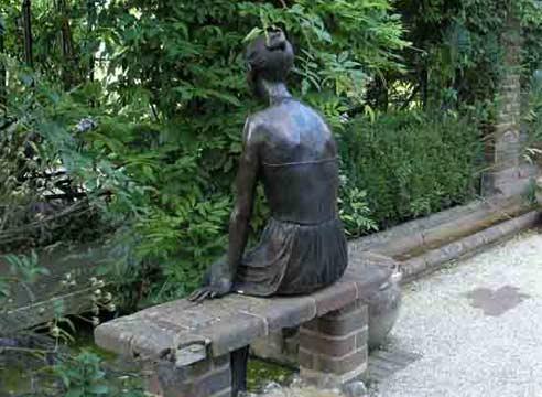 Скульптура девушки на скамейке