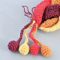 Многоцветный шарф косичка с помпонами. Шаг 3