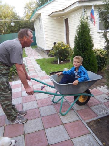Катание внука на садовой тачке,лучшая зарядка и развлечение для обоих! 