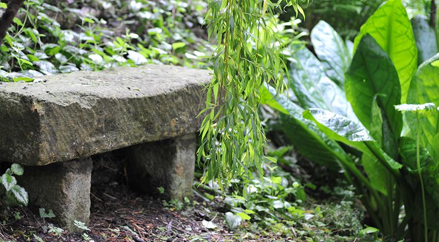 Каменная садовая скамья в саду MillDene Garden